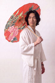 Ombrelle japonaise 'Aka' ouverte et tenue par un mannequin en kimono blanc — toile rouge profond à pivoines et feuillage vert