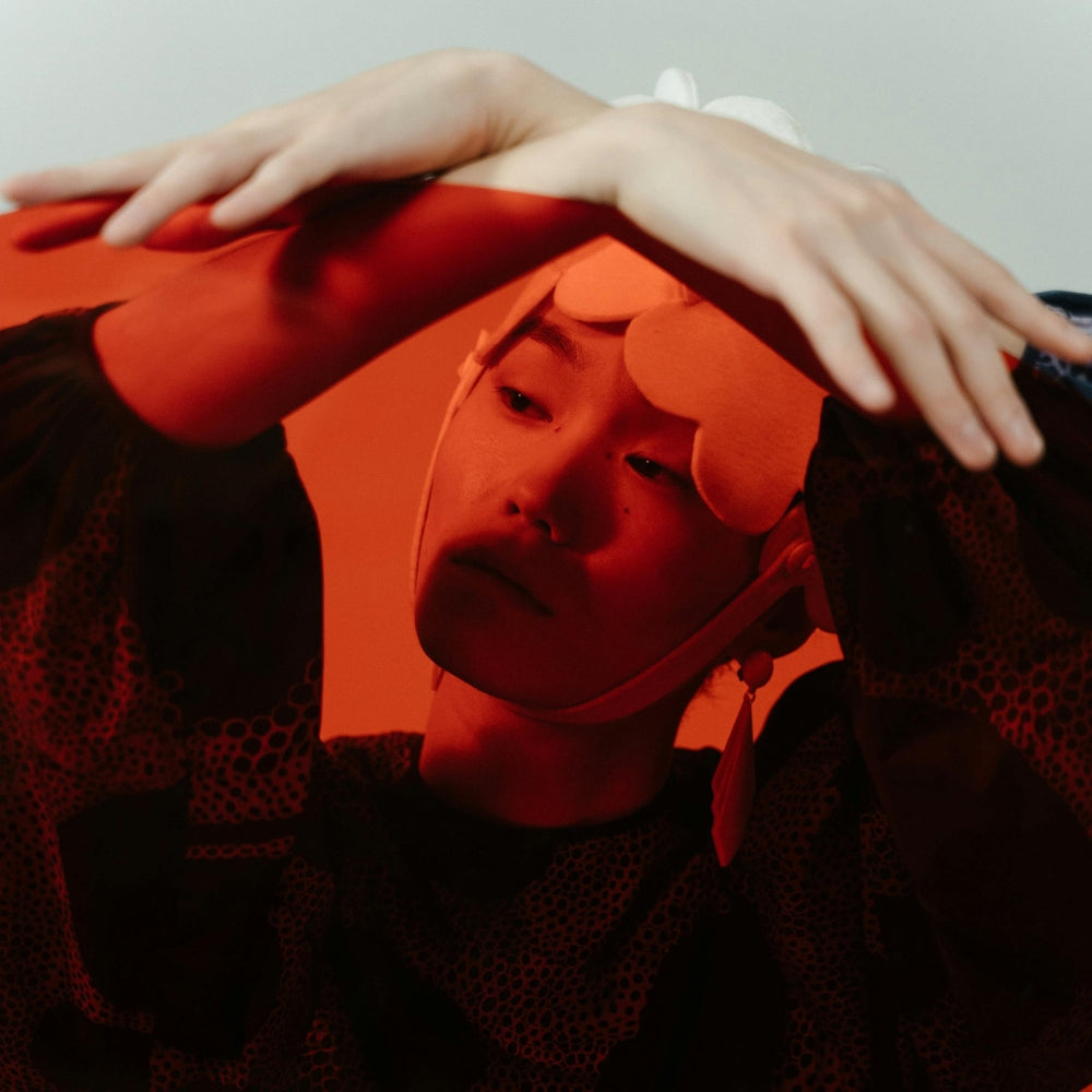 Portrait artistique d’un modèle japonais sous lumière rouge, exprimant le style avant-gardiste et la créativité de la mode japonaise contemporaine – Japanstreet