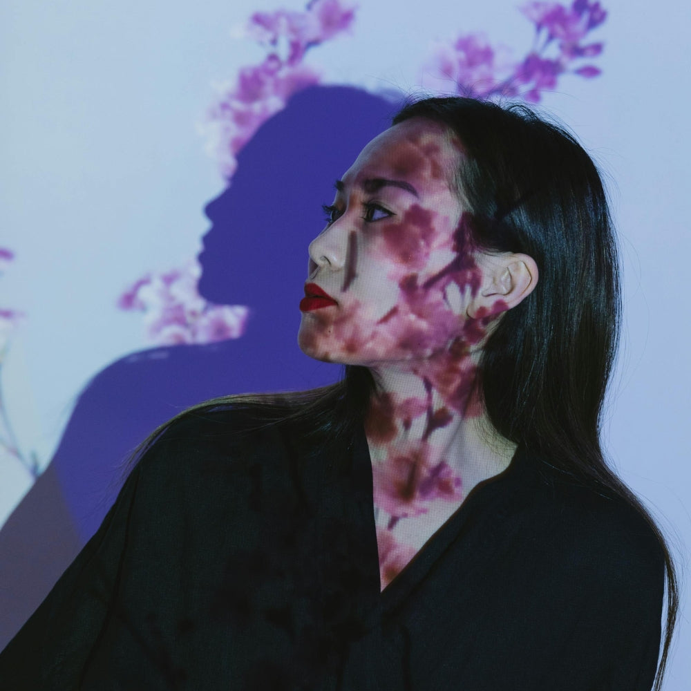 Portrait d’une femme japonaise avec projection de fleurs de cerisier sur le visage, symbolisant la beauté et l’élégance de la mode japonaise moderne – Japanstreet