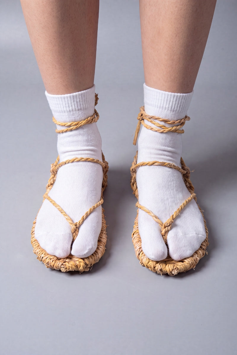 Sandales waraji portées sur des chaussettes tabi blanches, vue de face