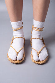 Sandales waraji portées sur des chaussettes tabi blanches, vue de face