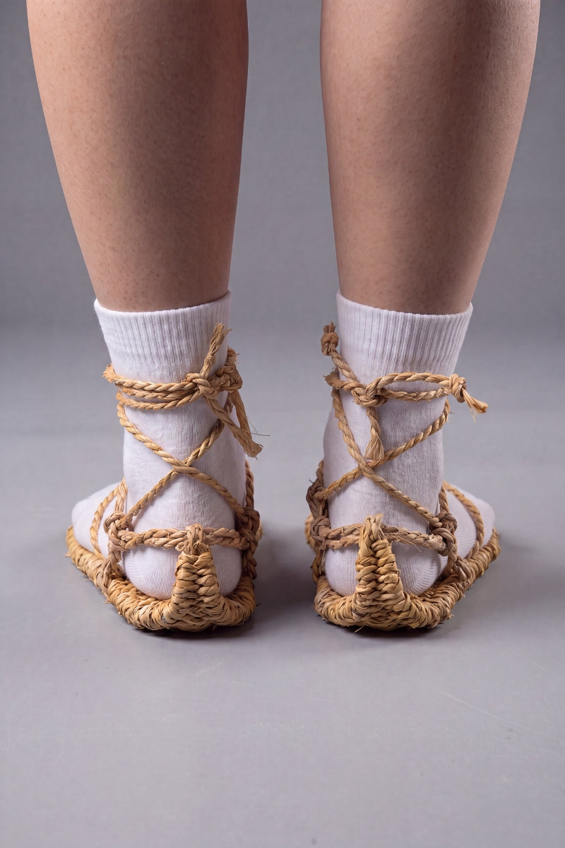 Sandales waraji vues de trois quarts arrière avec chaussettes tabi blanches, cordes nouées derrière la cheville
