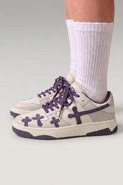Baskets basses 'Shiro' coloris violet — croix embossées sur les flancs, lacets épais assortis, portées avec chaussettes blanches sur fond studio gris