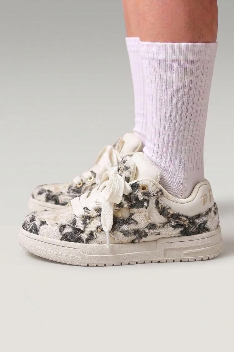 Baskets basses 'Yuki' coloris gris — toile unie sans surpiqûre apparente, semelle plate contrastée, portées avec chaussettes blanches sur fond studio gris