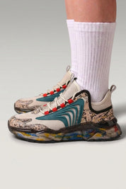 Baskets chunky 'Kariya' coloris gris — imprimé tribal intégral, semelle translucide à confettis, portées avec chaussettes blanches sur fond studio gris