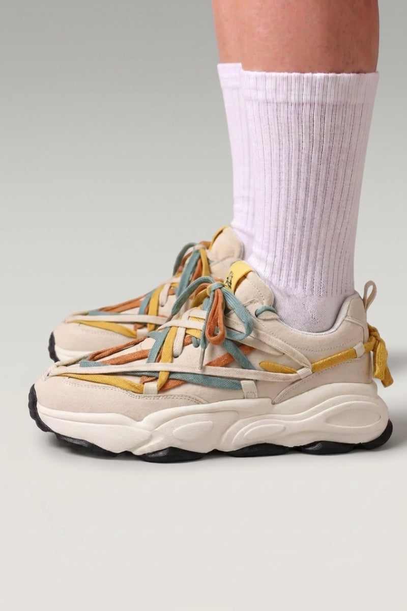 Baskets chunky 'Fujioka' coloris beige — double laçage multicolore, semelle épaisse crème, portées avec chaussettes blanches sur fond studio gris