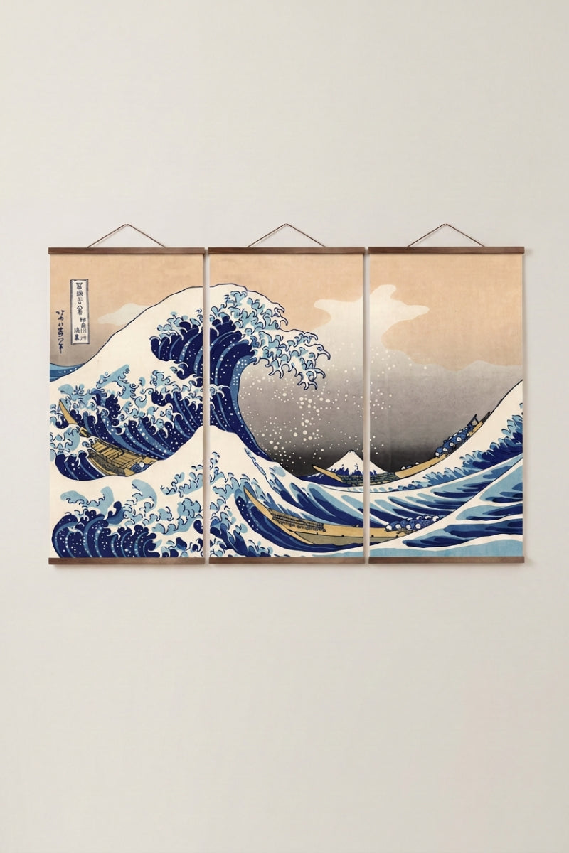 Triptyque japonais 'Kanagawa' accroché à un mur beige — la grande vague d'Hokusai répartie sur trois panneaux à tringles de bois clair