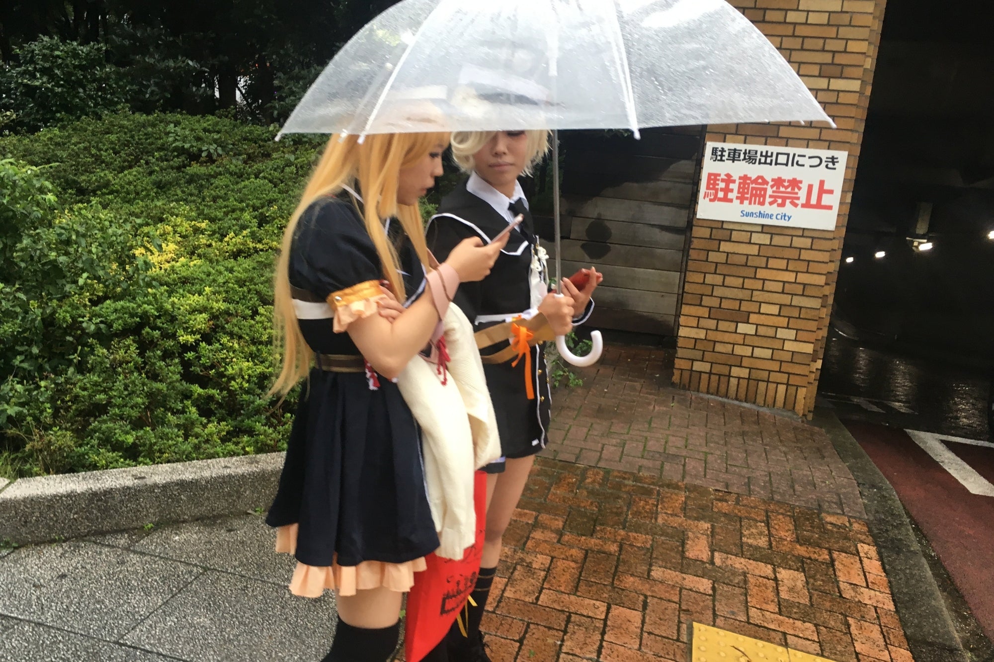 Deux jeunes cosplayeurs sous un parapluie à Sunshine City, Tokyo, représentant la créativité et l’univers du cosplay japonais.