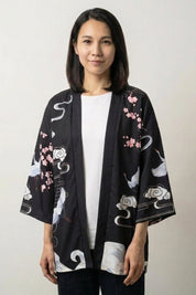 Veste kimono femme Osaka noire, imprimé de fleurs de prunier blanches et vagues stylisées, portée ouverte - Japanstreet