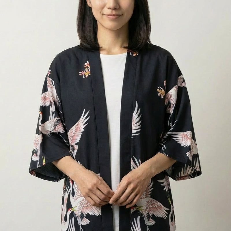 Veste kimono courte femme Annaki noire, imprimé de grues blanches et fleurs rouges, portée ouverte sur un t-shirt - Japanstreet