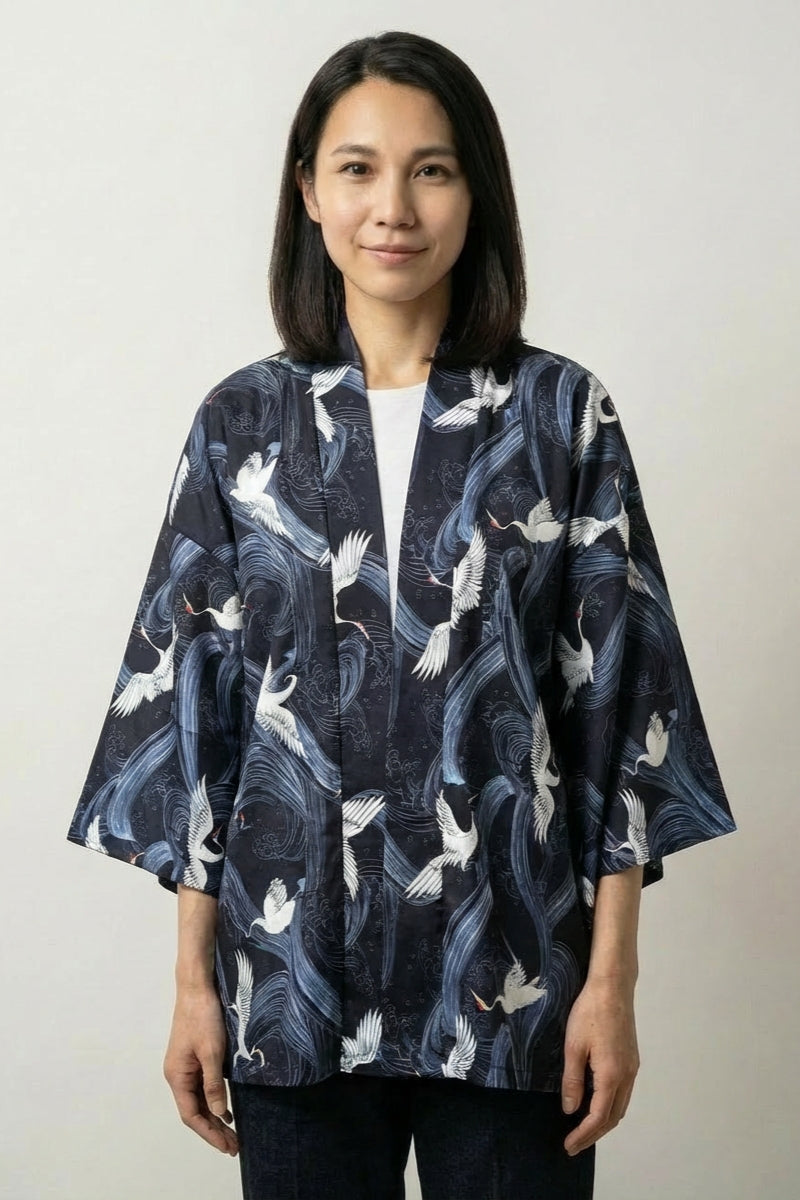 Veste kimono femme Shikuru bleu marine, imprimé all-over de grues blanches en vol, portée ouverte - Japanstreet