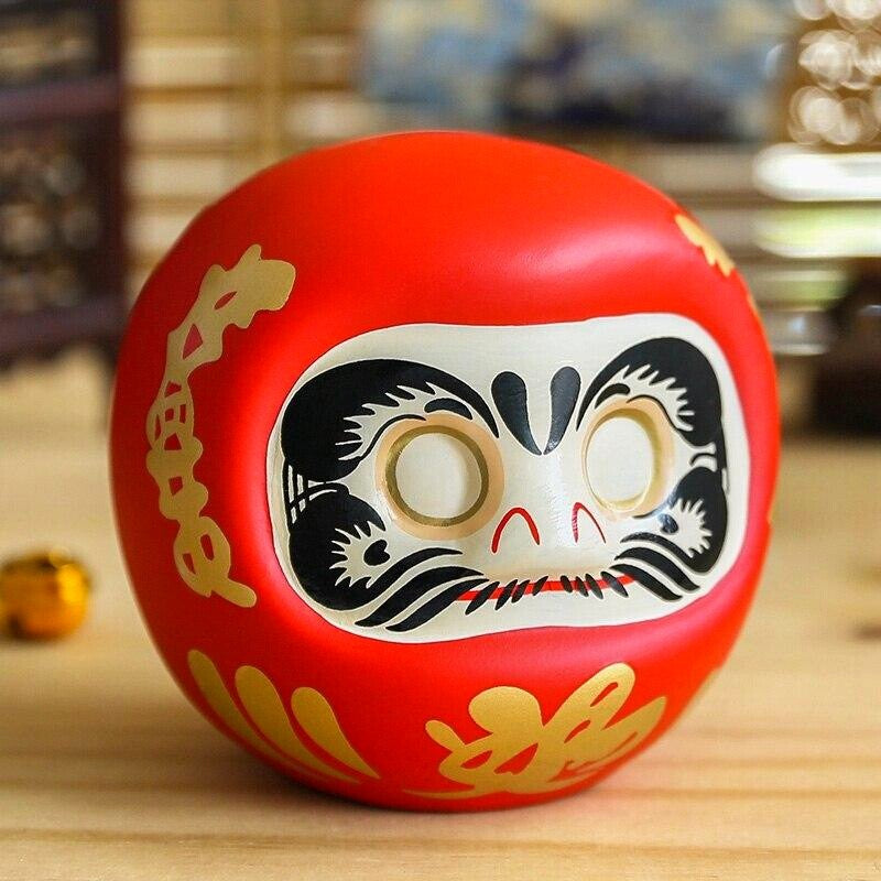 Daruma bordeaux à yeux entièrement vides prêt pour le rite du vœu, tirelire porcelaine peinte main — vue de détail visage — J