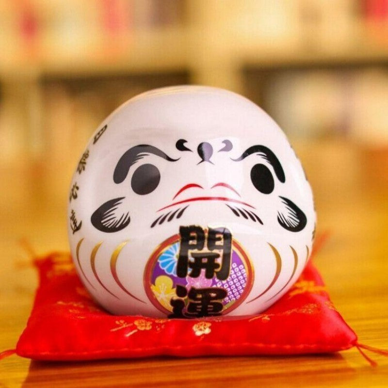 Daruma blanc à kanji 開運 kaiun (ouvrir la chance) pour vœu de Nouvel An, tirelire porcelaine peinte main — vue de détail visag