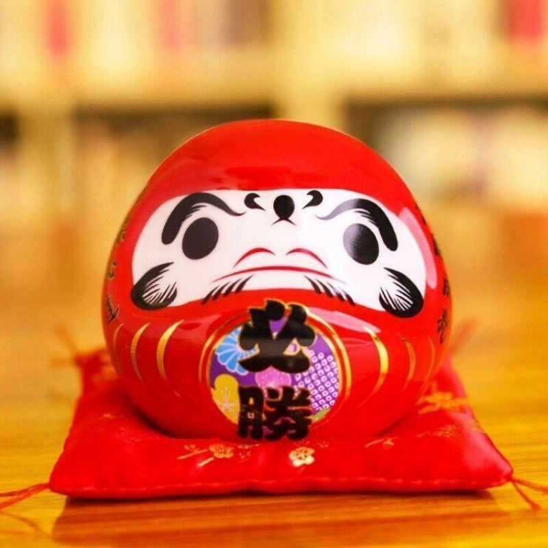 Daruma rouge classique à kanji 必勝 hisshō (victoire certaine) tradition Takasaki, tirelire peinte main — vue de détail visage 