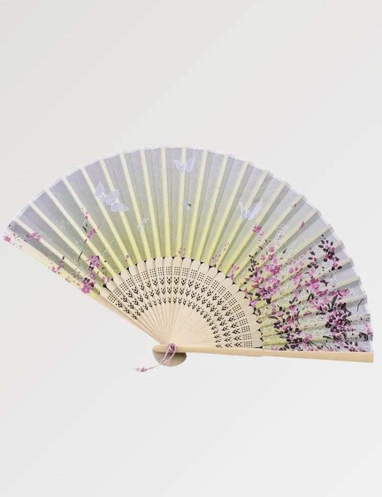 Un éventail japonais jaune au motif fleuri, accessoire indissociable de la geisha