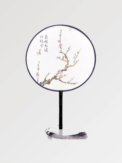 Un éventail rond aux écritures japonaises orné d'une branche ou les sakura fleurissent